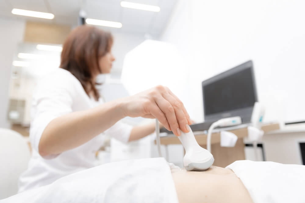 Lekarz wykonuje badanie usg piersi.