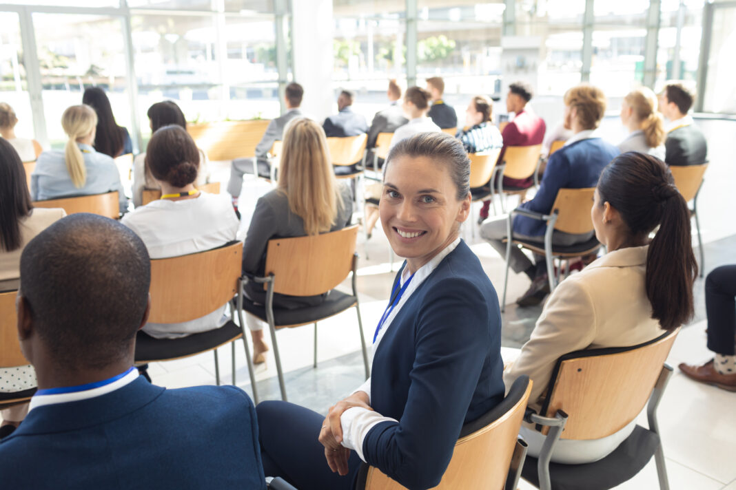 Caucasian female executive sat in conference room, smiling to camera